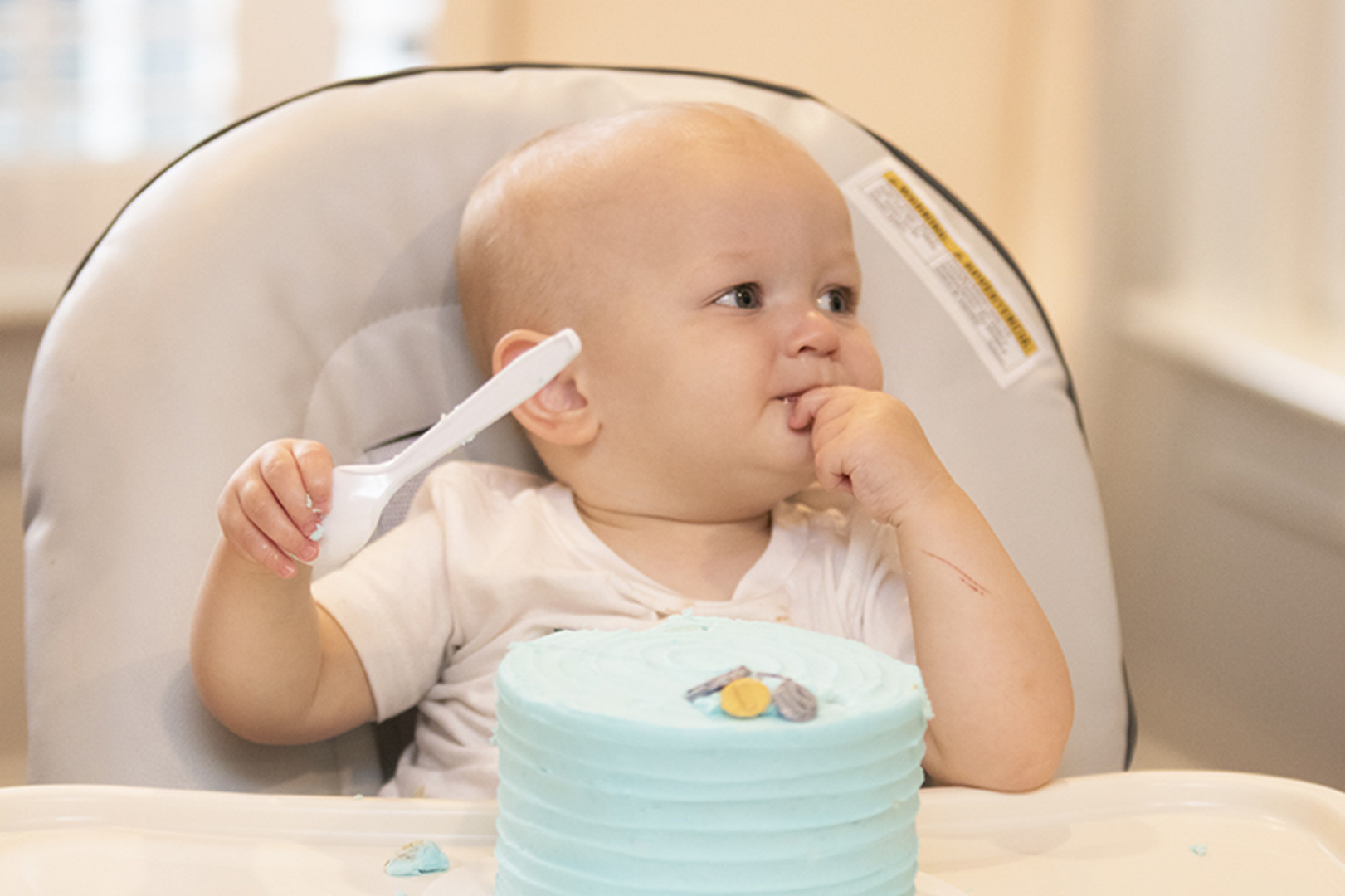 one year old boy with blue smash cake at first birthday party