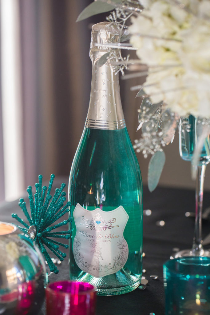 blue champagne bottle on New Year's eve table