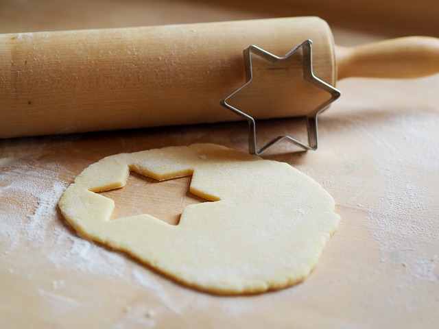 sugar cookie dough with a rolling pin and a star cookie cutter