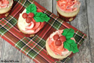 Looking for Christmas Cupcake ideas for the holidays? Our Holly Cupcake Recipe is a fancy dessert that's still easy to make! The cute fondant leaves and M&M berries really stand out on the candy cane inspired frosting. Click for the full recipe! #holidaybaking #holidayrecipes #Christmas