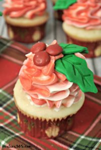 Looking for Christmas Cupcake ideas for the holidays? Our Holly Cupcake Recipe is a fancy dessert that's still easy to make! The cute fondant leaves and M&M berries really stand out on the candy cane inspired frosting. Click for the full recipe! #holidaybaking #holidayrecipes #Christmas