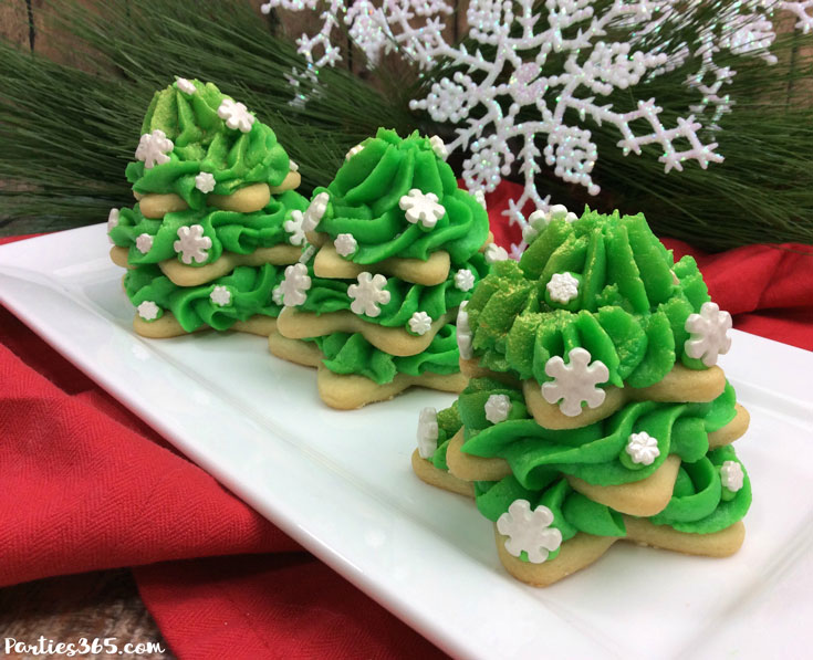 stacked Christmas tree sugar cookies with green icing on a white plate