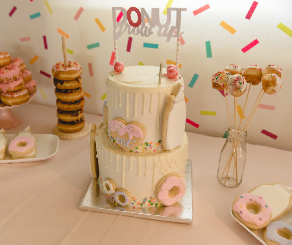 donut grow up cake topper and birthday cake on dessert table 