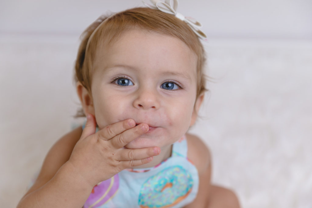 little girl blowing a kiss at her first birthday photoshoot