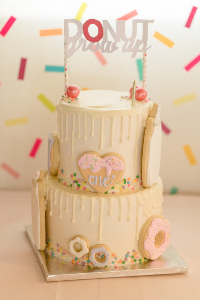 donut grow up cake topper and first birthday cake covered in donut cookies