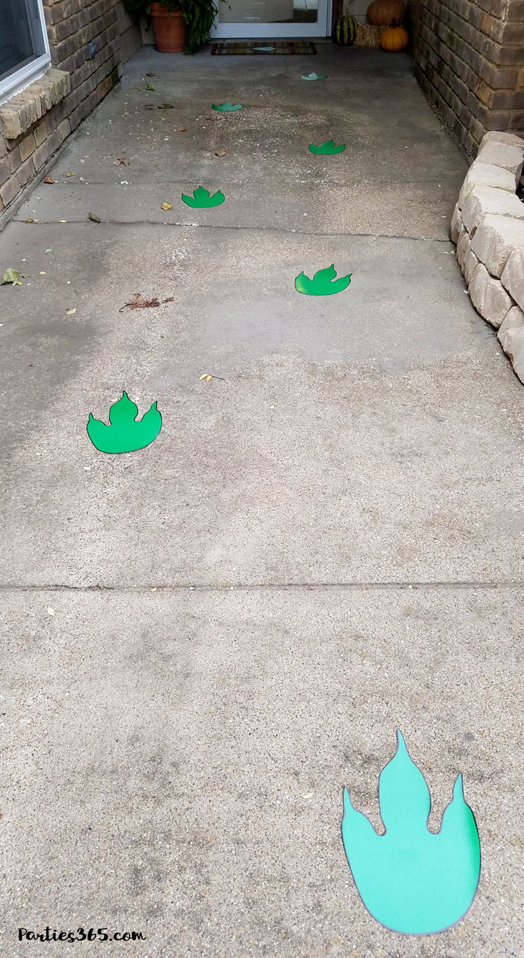 green dinosaur footprints on sidewalk