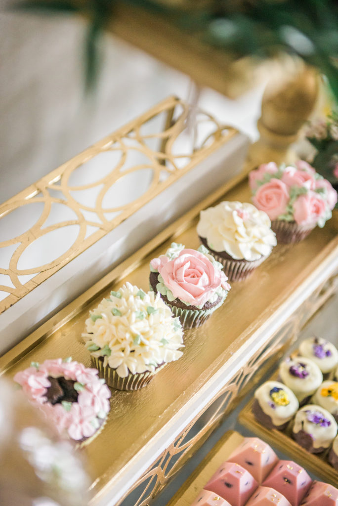 flower covered cupcakes on dessert table