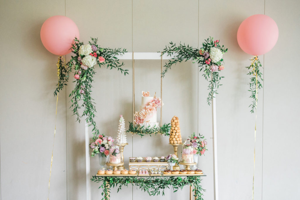 Spring garden party dessert table with flowers and pink balloons