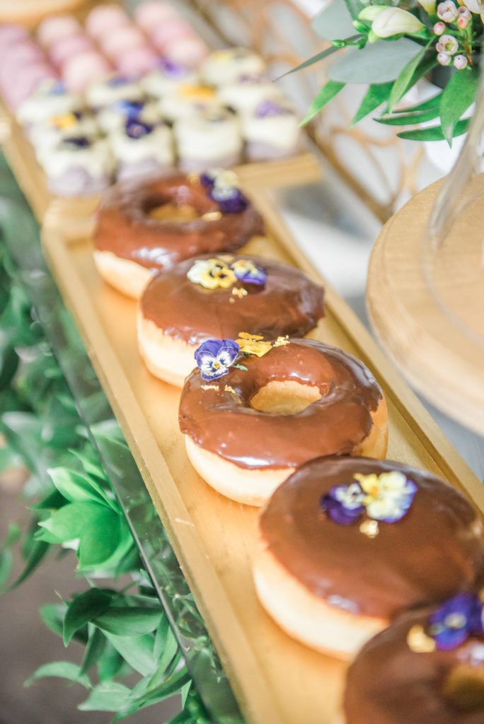 edible flowers on chocolate glazed donuts