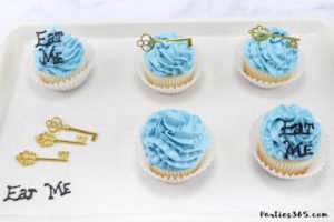 These simple DIY cupcake toppers are perfect for your Alice in Wonderland theme party! The gold key and "Eat Me" decorations are easy ideas to make your party food whimsical and fun for all ages! #AliceinWonderland #cupcakes #TeaPartyIdeas