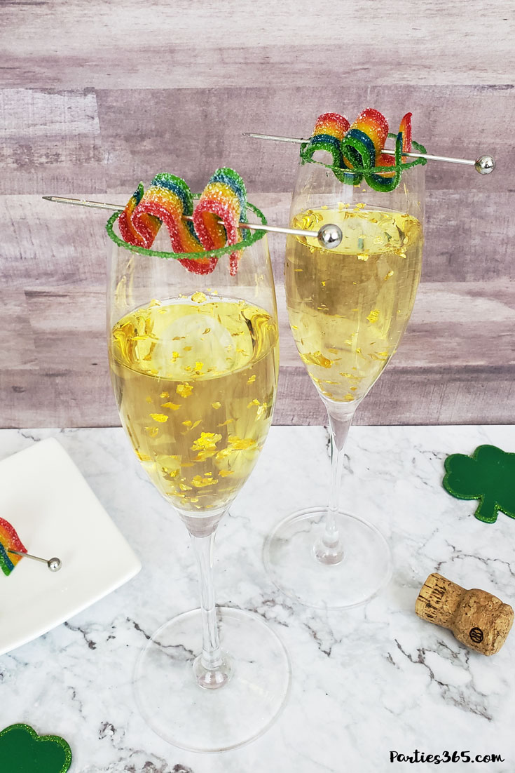 This festive St. Patrick's Day champagne cocktail is a fun and easy drink idea for your party! The simple recipe with sparkling wine, isn't green, but the gold under the rainbow will delight any St. Pattys leprechaun! #stpatricksday #champagne #cocktailrecipe #rainbow