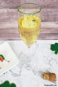 This festive St. Patrick's Day champagne cocktail is a fun and easy drink idea for your party! The simple recipe with sparkling wine, isn't green, but the gold under the rainbow will delight any St. Pattys leprechaun! #stpatricksday #champagne #cocktailrecipe #rainbow