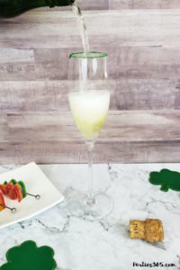 This festive St. Patrick's Day champagne cocktail is a fun and easy drink idea for your party! The simple recipe with sparkling wine, isn't green, but the gold under the rainbow will delight any St. Pattys leprechaun! #stpatricksday #champagne #cocktailrecipe #rainbow