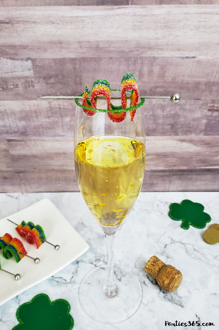 This festive St. Patrick's Day champagne cocktail is a fun and easy drink idea for your party! The simple recipe with sparkling wine, isn't green, but the gold under the rainbow will delight any St. Pattys leprechaun! #stpatricksday #champagne #cocktailrecipe #rainbow