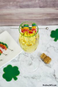 This festive St. Patrick's Day champagne cocktail is a fun and easy drink idea for your party! The simple recipe with sparkling wine, isn't green, but the gold under the rainbow will delight any St. Pattys leprechaun! #stpatricksday #champagne #cocktailrecipe #rainbow