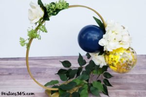 This unique DIY centerpiece, made from an Embroidery Hoop, flowers and mini balloons, is perfect for a party, birthday, wedding, graduation or anniversary! This simple crafts project tutorial will show you how to create beautiful decor for your big event! #centerpiece #embroideryhoop #partydecor #partyideas