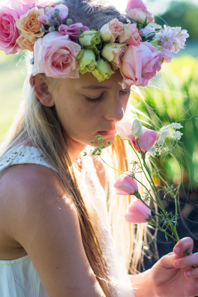 teenage girl wearing floral crown in a field