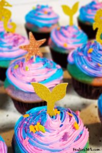 Want an easy idea for a DIY Mermaid Cupcake? This simple Under the Sea theme birthday cupcake is inspired by mermaid magic! We'll show you how to make them and give you ideas for cute toppers! #mermaidcupcake #mermaidparty #underthesea #cupcakes #partyideas