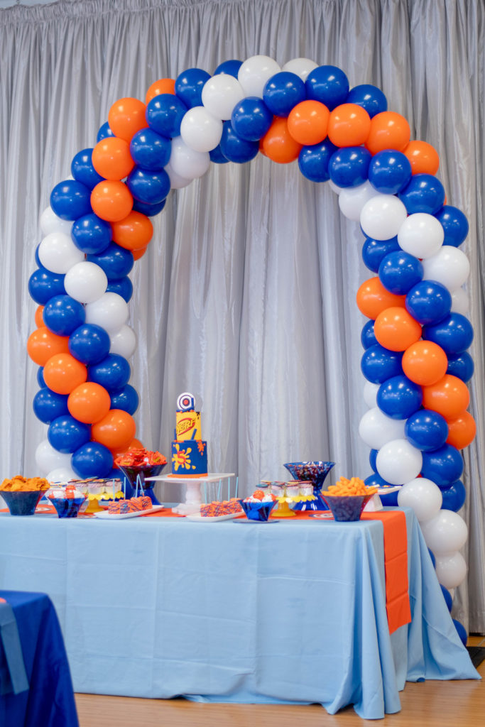 blue, white and orange balloon arch at nurf gun birthday party