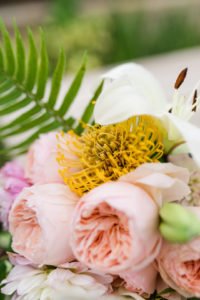 Want to set a beautiful outdoor dining table for a summer party? You'll love this simple tablescape featuring a palm leaf centerpiece and tropical decor! Click through to see all the summery tabletop decorations! #summerparty #outdoordining #tablescape #centerpiece #tropical