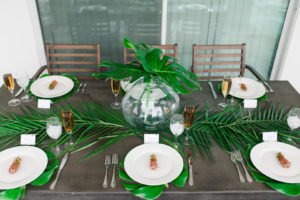 Want to set a beautiful outdoor dining table for a summer party? You'll love this simple tablescape featuring a palm leaf centerpiece and tropical decor! Click through to see all the summery tabletop decorations! #summerparty #outdoordining #tablescape #centerpiece #tropical