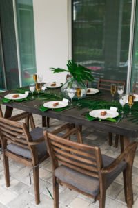 Want to set a beautiful outdoor dining table for a summer party? You'll love this simple tablescape featuring a palm leaf centerpiece and tropical decor! Click through to see all the summery tabletop decorations! #summerparty #outdoordining #tablescape #centerpiece #tropical