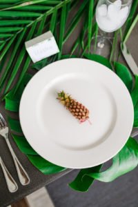 Want to set a beautiful outdoor dining table for a summer party? You'll love this simple tablescape featuring a palm leaf centerpiece and tropical decor! Click through to see all the summery tabletop decorations! #summerparty #outdoordining #tablescape #centerpiece #tropical