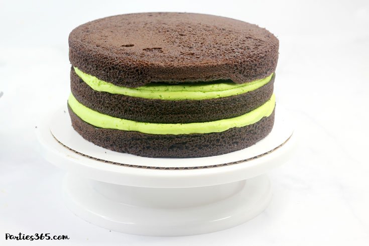 three chocolate cake layers with green icing