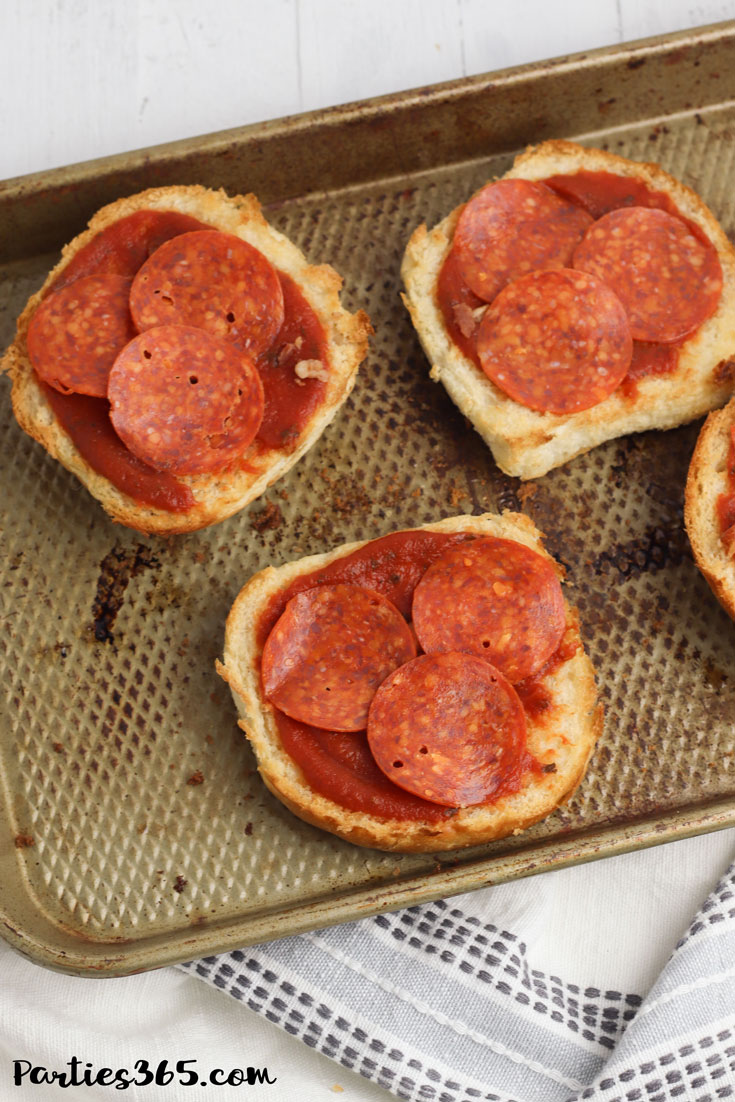pepperonis on toasted buns with pizza sauce