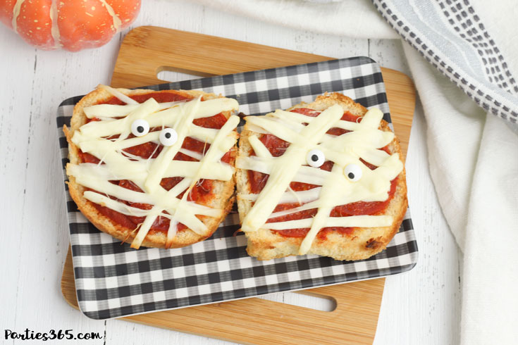 Halloween Mummy Pizzas on a black and white plaid tray