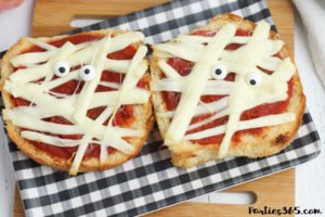 This super fun and easy Halloween Mummy Pizza recipe will be spooktacular for the kids! Whether you want to make a festive dinner for your family or something special for a Halloween party, these Mummy Pizzas are easy, quick and delicious! #Halloween #Halloweenrecipes #mummy #mummypizza #halloweenparty