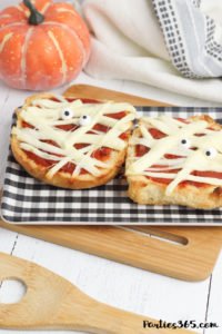 This super fun and easy Halloween Mummy Pizza recipe will be spooktacular for the kids! Whether you want to make a festive dinner for your family or something special for a Halloween party, these Mummy Pizzas are easy, quick and delicious! #Halloween #Halloweenrecipes #mummy #mummypizza #halloweenparty