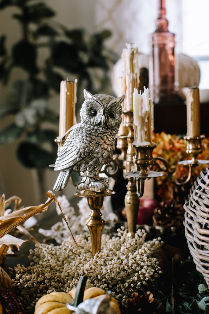 silver owl on a brass candlestick for fall dinner party centerpiece