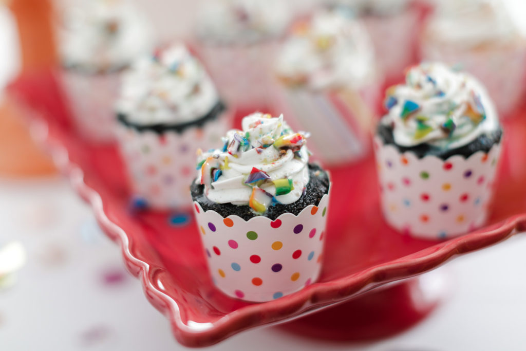chocolate cupcakes with rainbow sprinkles on red tray