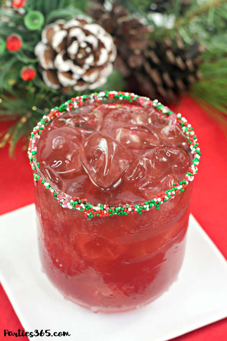 red christmas cocktail recipe in glass rimmed with red and green sprinkles