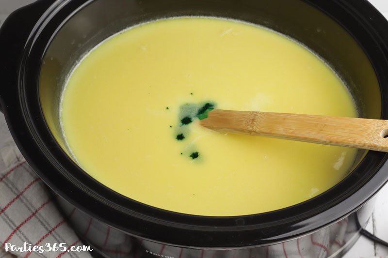 adding green food coloring to hot chocolate mix