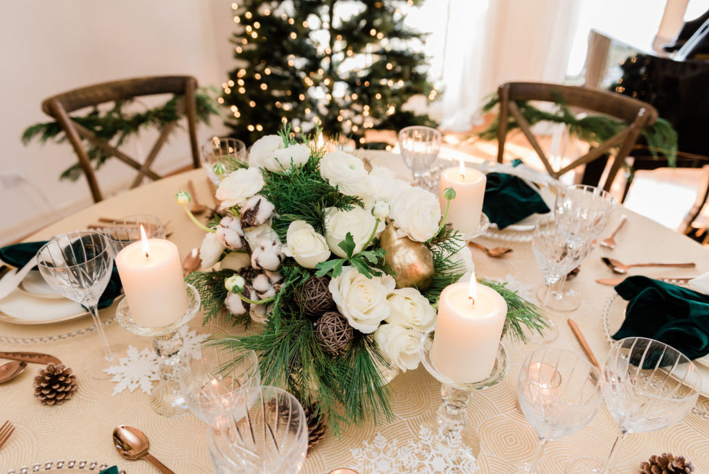 Christmas centerpiece with evergreen branches, pinecones and white roses