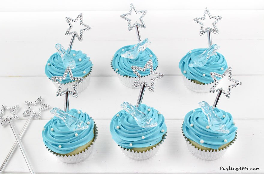 adding white sprinkles to blue cinderella cupcakes