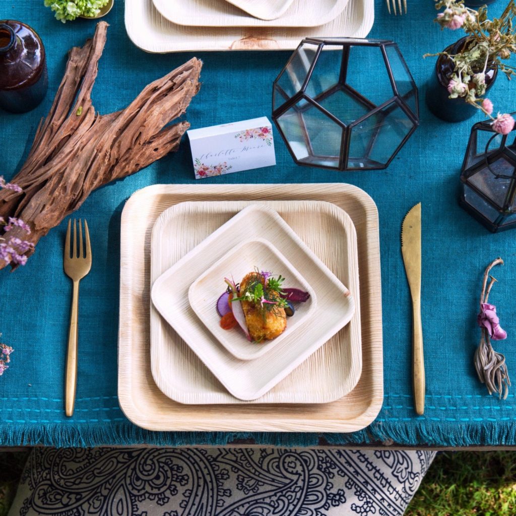compostable wooden plates on a blue tablecloth