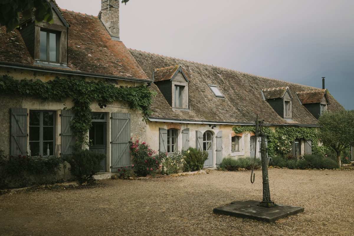 ferrock gravel driveway alternative — stone farmhouse with a compacted gravel courtyard driveway that ferrock aims to replace