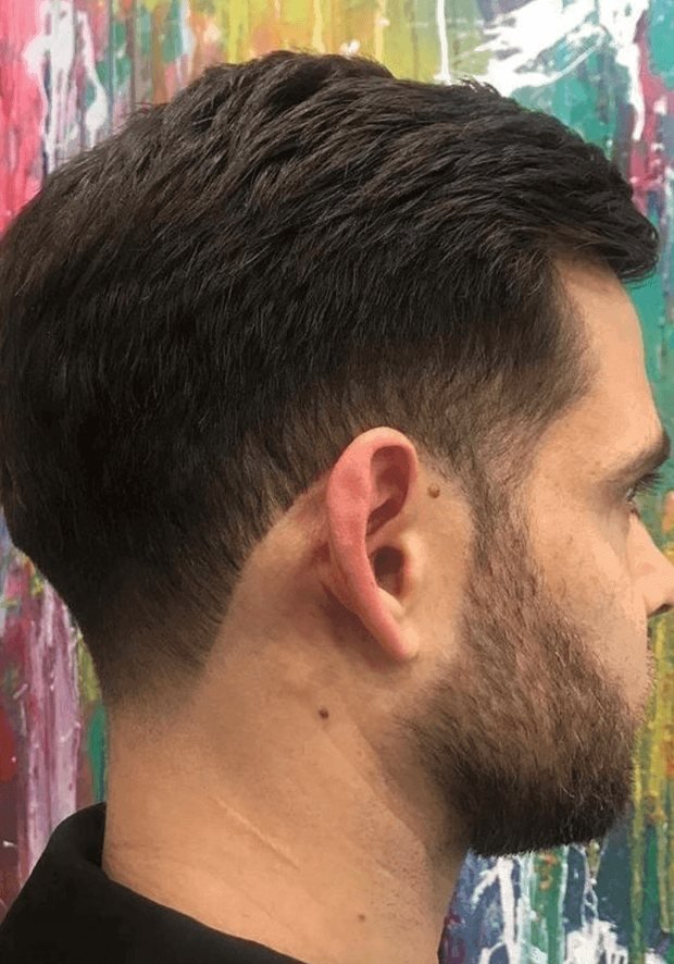 Side view of a man with short dark hair and a trimmed beard, a Rush Hair & Beauty photo for blend-away greys