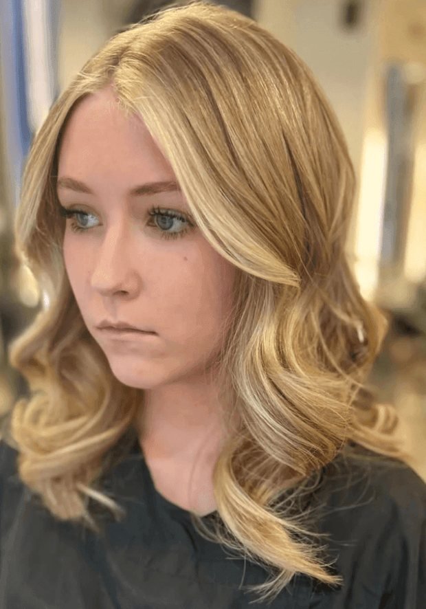 Woman with long golden-blonde waves brightened around the parting and face, a Rush Hair & Beauty photo